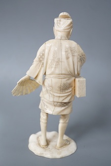 A Japanese carved ivory figure, Meiji period, of an actor, having a noh mask on the crown of his head and holding a fan, incised signature to base, height 16cm